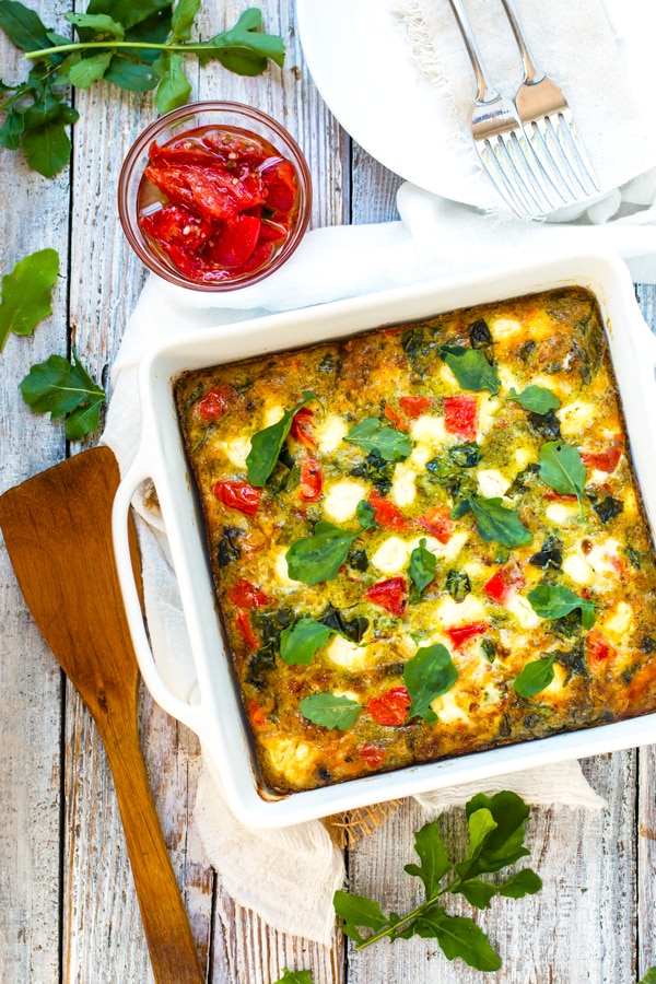 An overhead picture of a gluten-free breakfast frittata with a wooden serving spoon on the side.