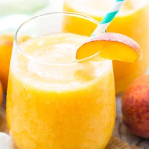 Two glasses filled with Frozen Peach White Wine Sangria for a delicious summer treat.