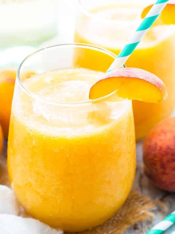 Two glasses filled with Frozen Peach White Wine Sangria for a delicious summer treat.