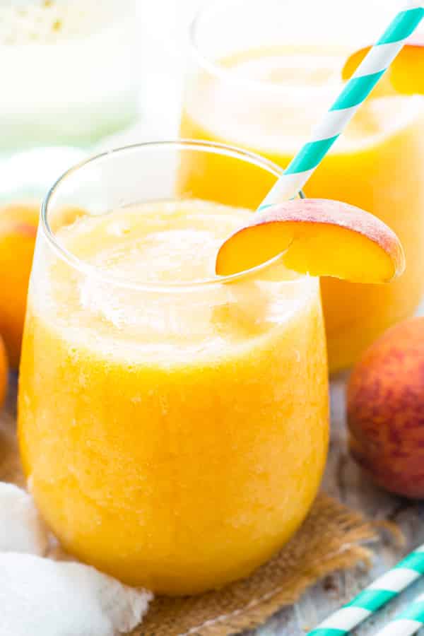 Two glasses filled with Frozen Peach White Wine Sangria for a delicious summer treat.