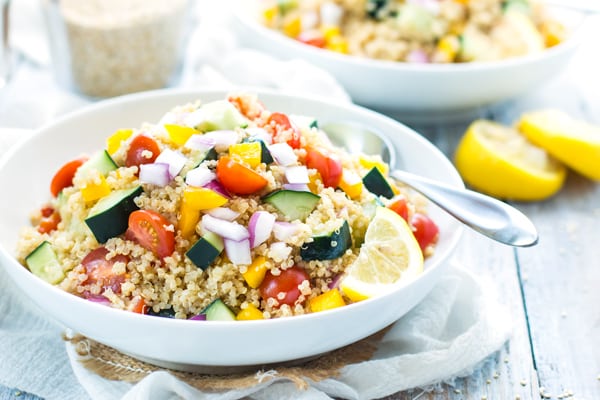 A bowl of the best quinoa salad with vegetables and lemon vinaigrette for a summer get-together.