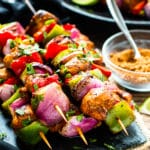 A stack of Grilled Fajita Chicken Kabobs on a blue slab for a healthy lunch.