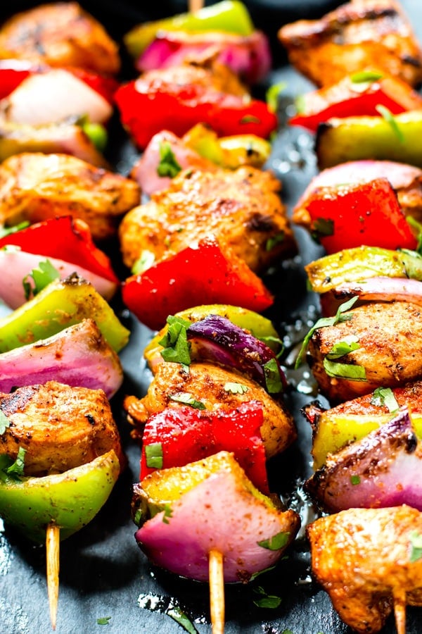 A row of gluten-free grilled chicken kabobs for a low-carb appetizer.