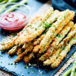 Oven baked asparagus fries on a serving slab ready for a healthy dinner.