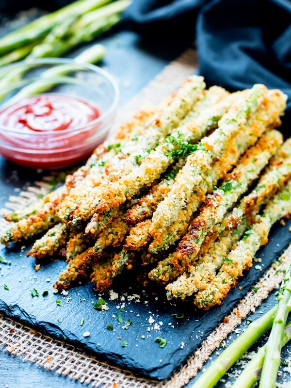 Oven baked asparagus fries on a serving slab ready for a healthy dinner.