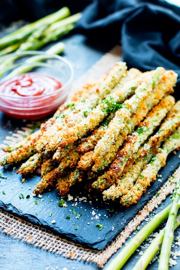 Oven baked asparagus fries on a serving slab ready for a healthy dinner.