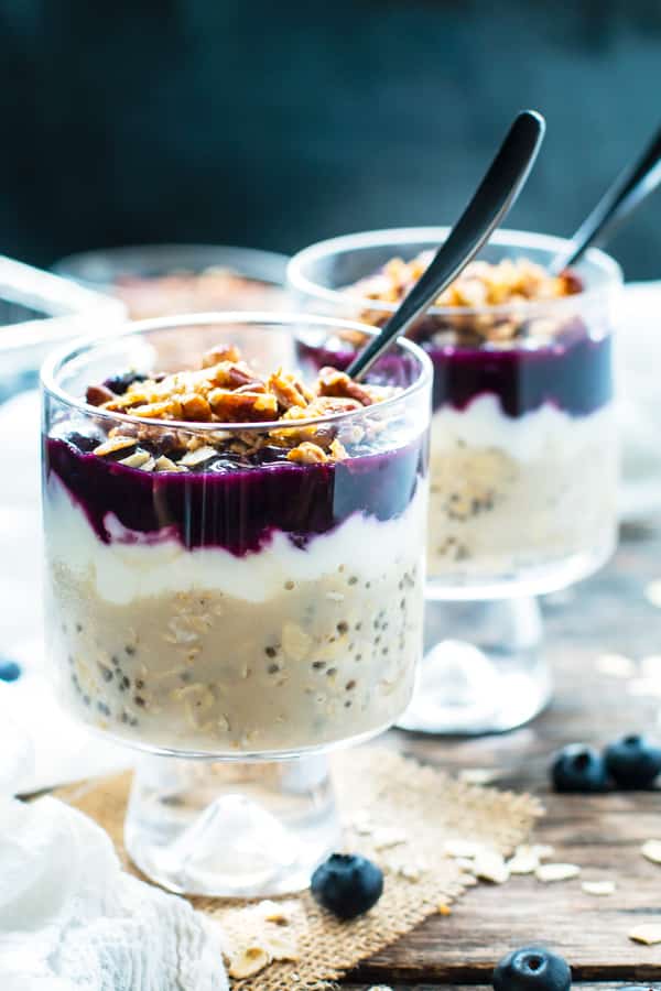 Two servings of Healthy Blueberry Overnight Oats topped with pecans and chia seeds.