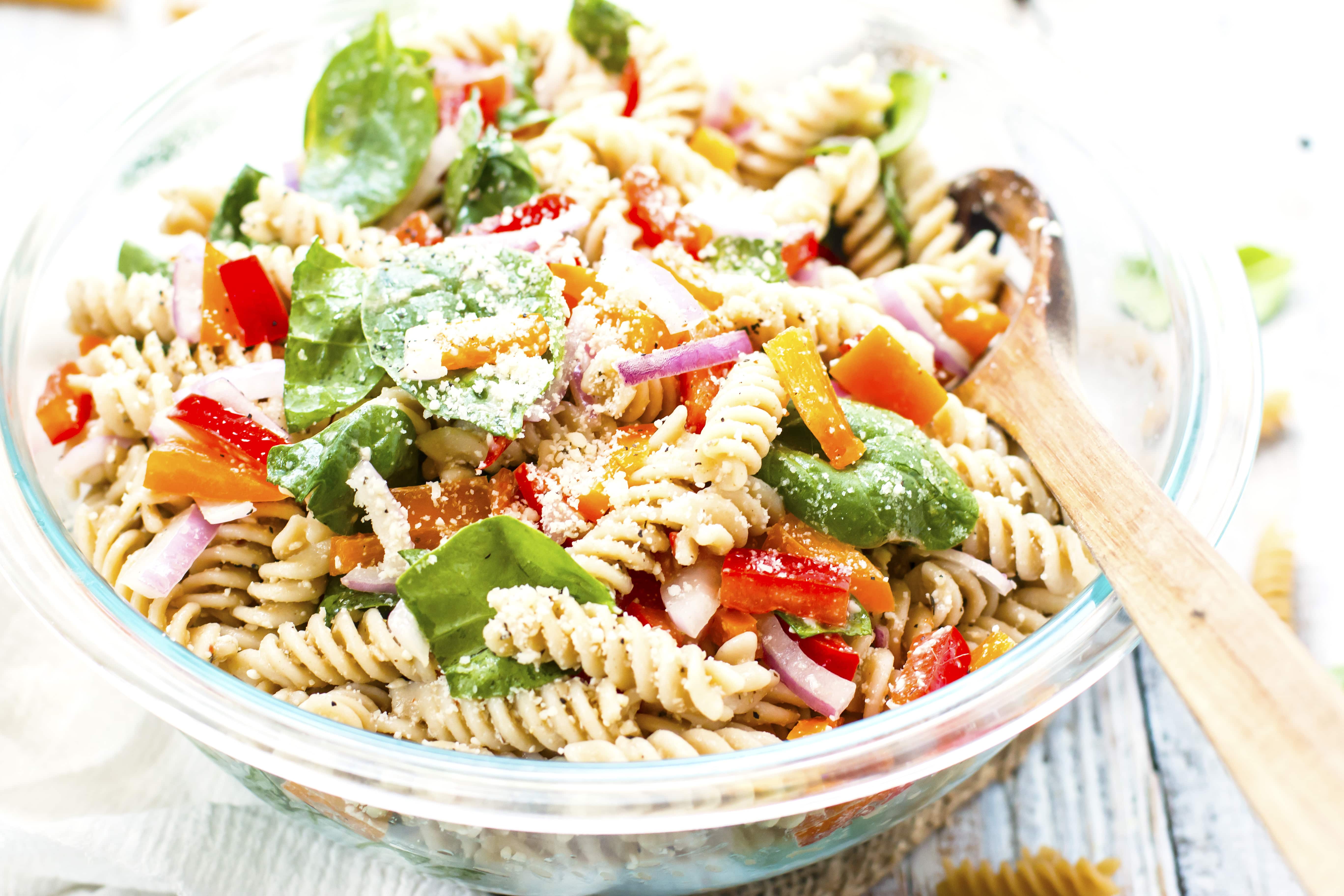 Gluten-free pasta salad with Italian dressing in a glass bowl for a summer party.