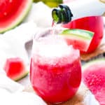 Pouring Champagne into a single tequila drink with watermelon for an adult beverage.