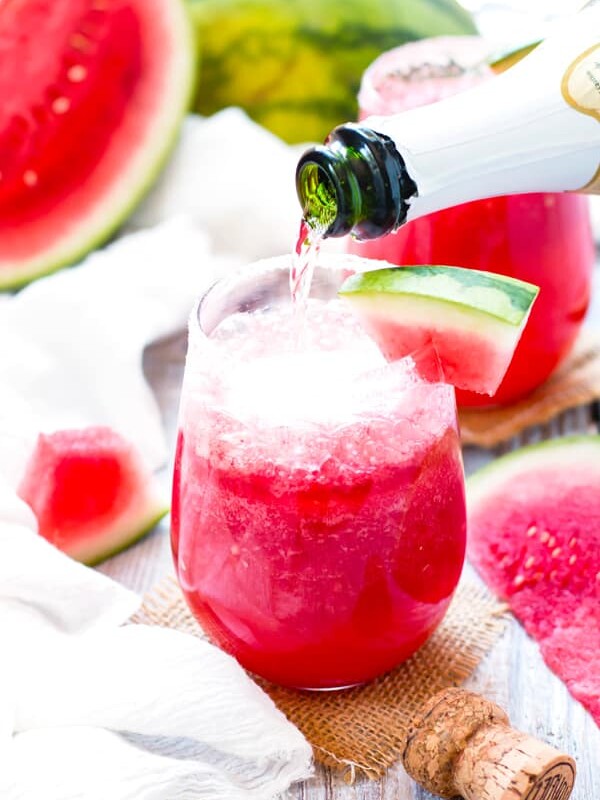 Pouring Champagne into a single tequila drink with watermelon for an adult beverage.