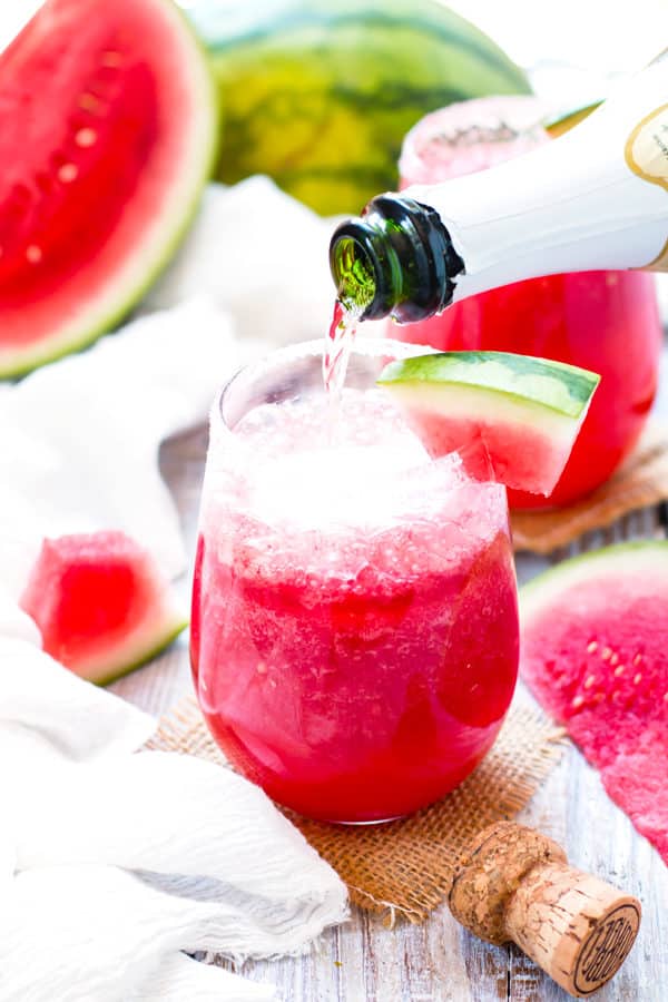 Pouring Champagne into a single tequila drink with watermelon for an adult beverage.
