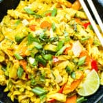 An overhead picture of Golden Thai Curry Noodles in a bowl with lime slices and chopsticks.