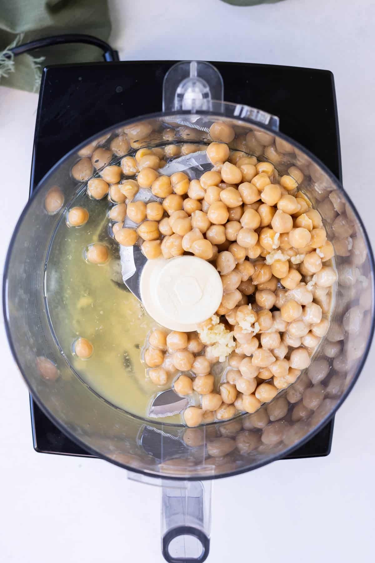 Chickpeas are added to a food processor.