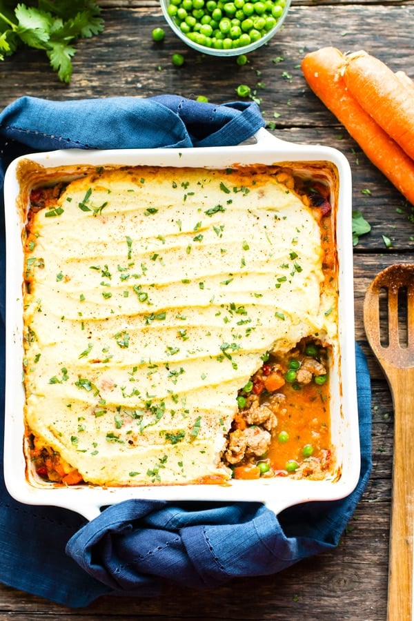 Paleo shepherd's pie in a dish with a blue napkin ready for a delicious dinner.