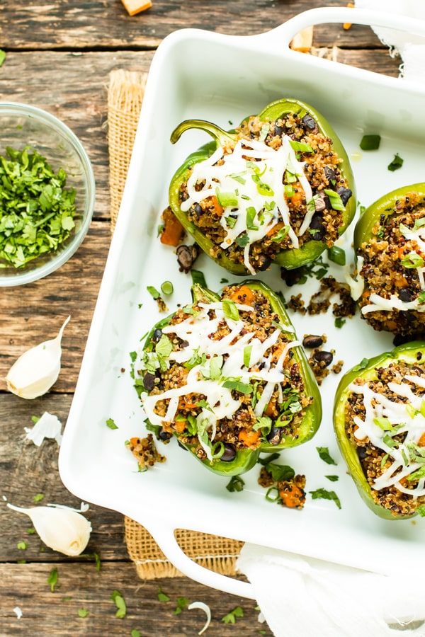 Gluten-free Black Bean & Quinoa Stuffed Bell Peppers in a casserole dish on a table for a healthy dinner.