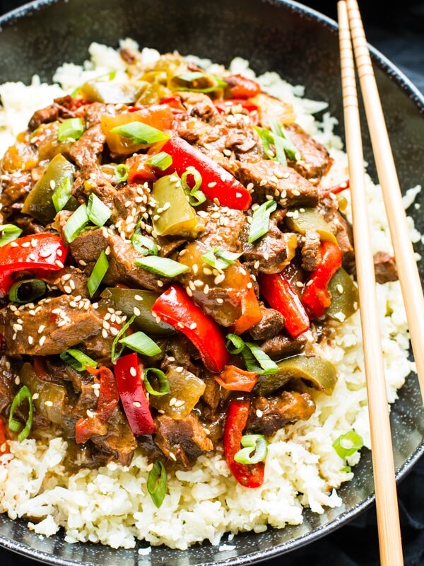 Gluten-free Beef Teriyaki in a bowl on top of rice with chopsticks.