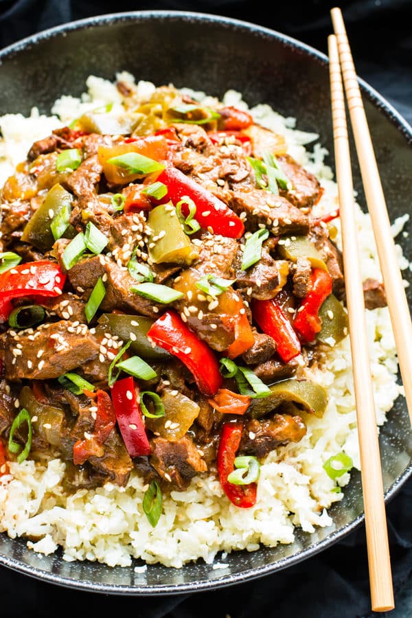 Gluten-free Beef Teriyaki in a bowl on top of rice with chopsticks.