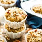Two Vegan Maple Pecan Oatmeal Muffins on top of one another on a table.