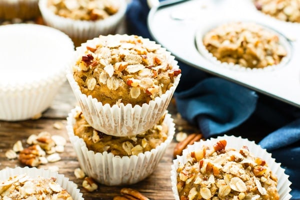 Two Vegan Maple Pecan Oatmeal Muffins on top of one another on a table.