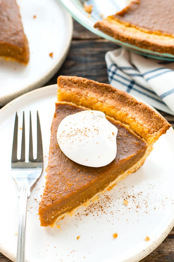 A piece of easy pumpkin pie on a plate with a fork for Thanksgiving dinner.