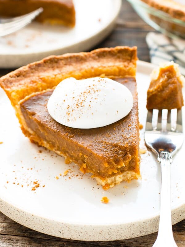 A single piece of gluten-free pumpkin pie with whipped cream on the top for dessert.