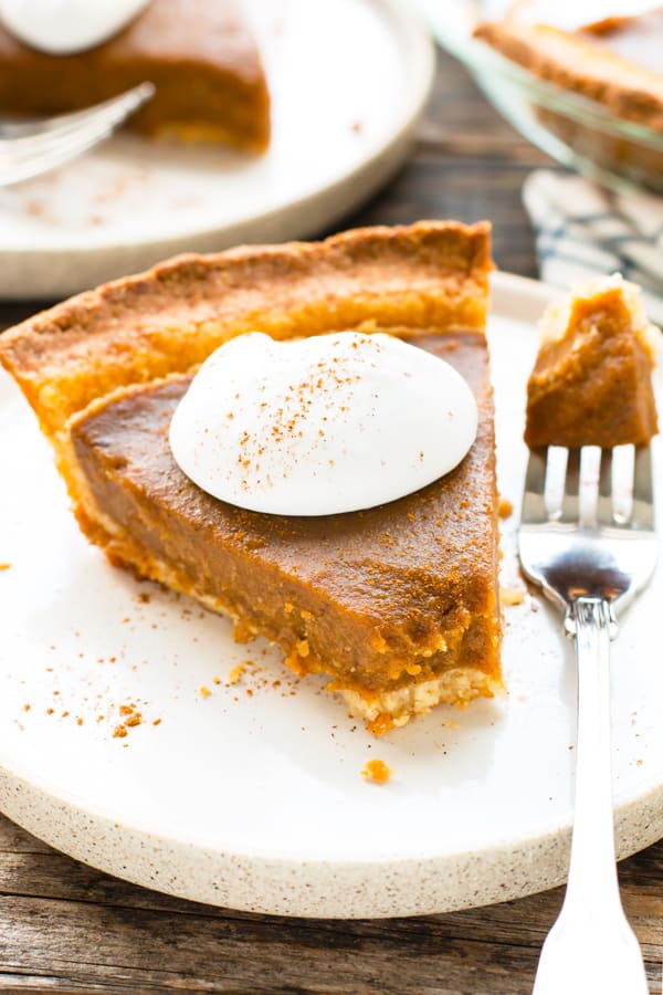 A single piece of gluten-free pumpkin pie with whipped cream on the top for dessert.