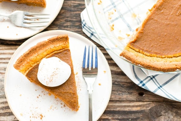 A piece of vegan pumpkin pie on a white plate for the holidays.