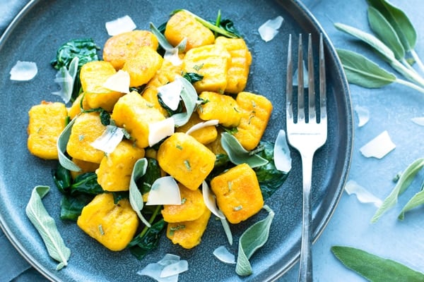 An overhead picture of gluten-free Butternut Squash Gnocchi with fresh herbs as a garnish.