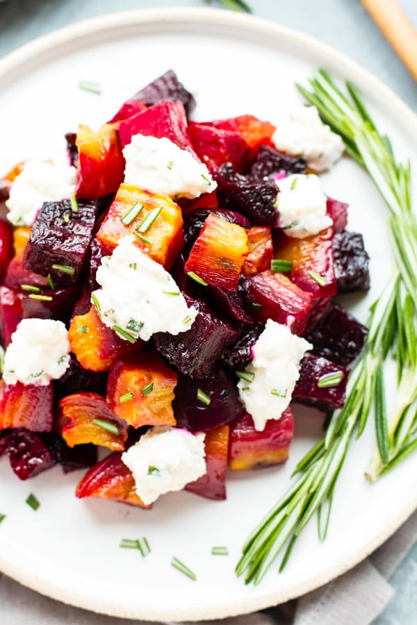 An overhead picture of gluten-free Oven-Roasted Beets on a white plate with fresh herbs.