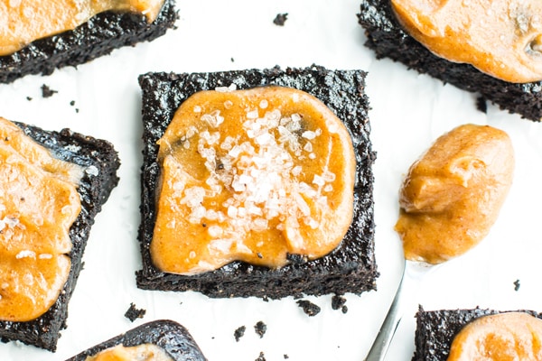 A piece of gluten-free Salted Caramel Fudgy Paleo Brownies with a spoon filled with caramel.