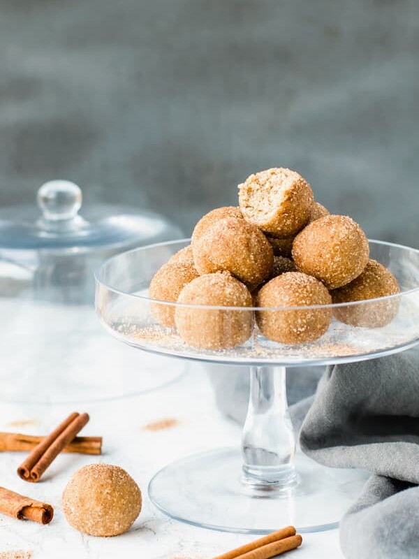 A bitten off ball of Snickerdoodle Cookie Dough Bites on a glass tray for a healthy treat.