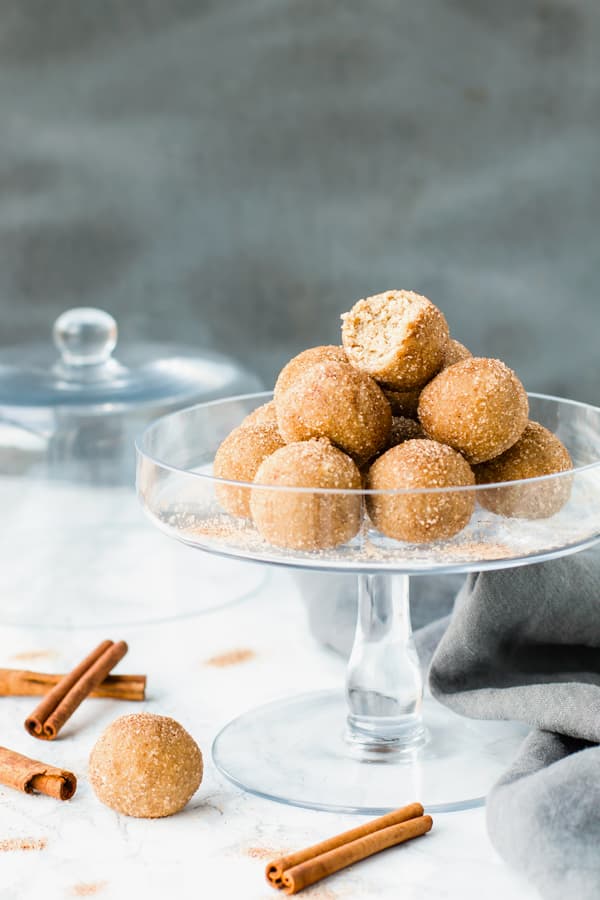 A bitten off ball of Snickerdoodle Cookie Dough Bites on a glass tray for a healthy treat.
