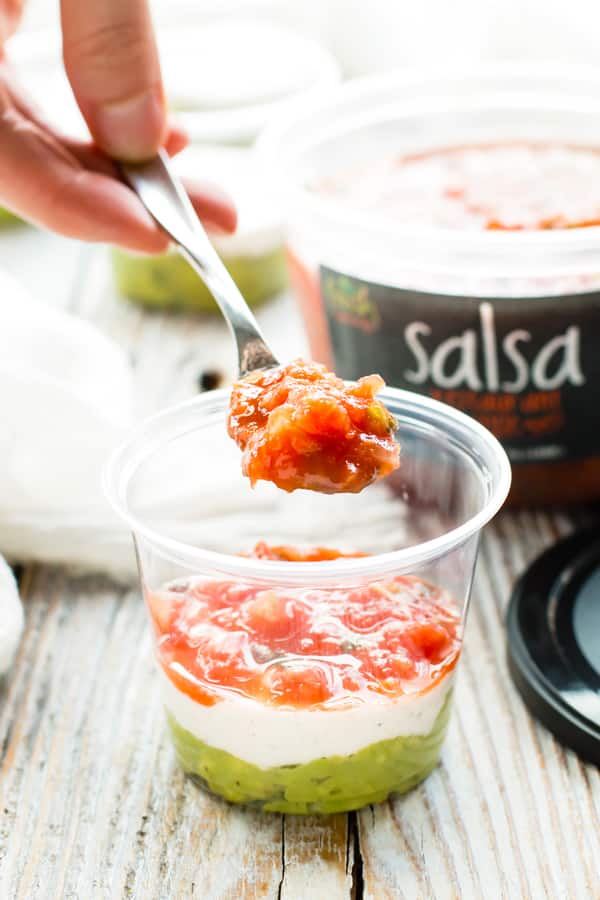 A spoonful of Healthy 7-Layer Dip using Fresh Cravings Salsa.