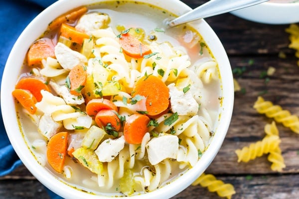 An overhead picture of gluten-free soup made with chicken, noodles, and vegetables.