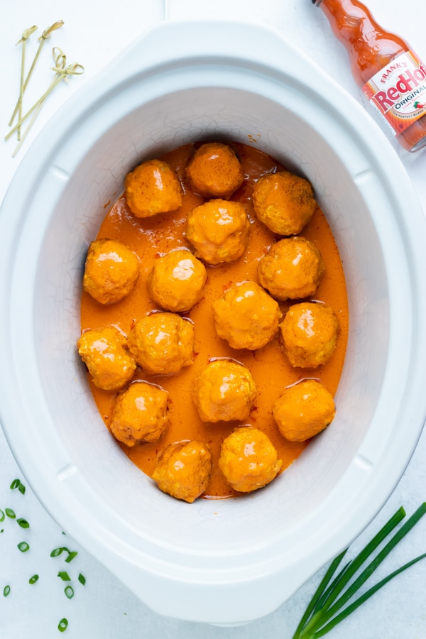A 6-quart slow cooker full of easy, low-carb meatballs covered in a buffalo sauce.