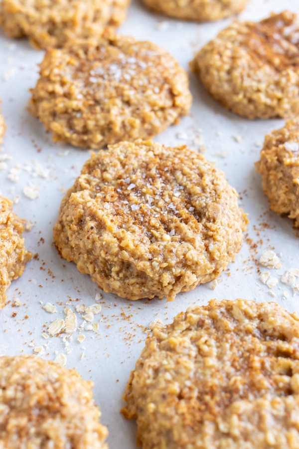 Almond butter oatmeal cookies on a parchment paper lined baking sheet.