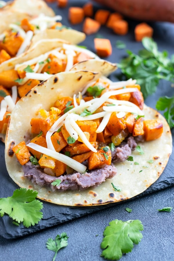 Vegetarian black bean sweet potato tacos with cheese in a corn tortilla.