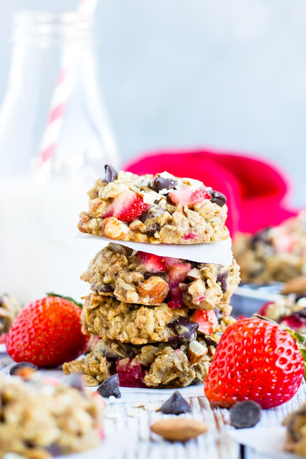 A stack of Chocolate Chip Oatmeal Cookies with Strawberries and milk for dessert.