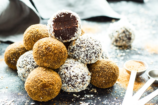 Gluten-free paleo fudge truffles in a pile on a gray table.