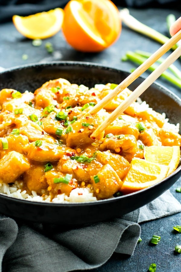 Healthy paleo Instant Pot chicken recipe for orange chicken in a black bowl with chopsticks.