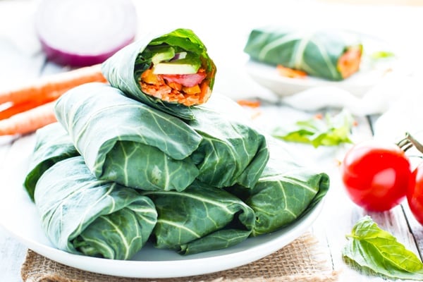 A pile of vegetarian wraps made with raw veggies and hummus for a healthy lunch.