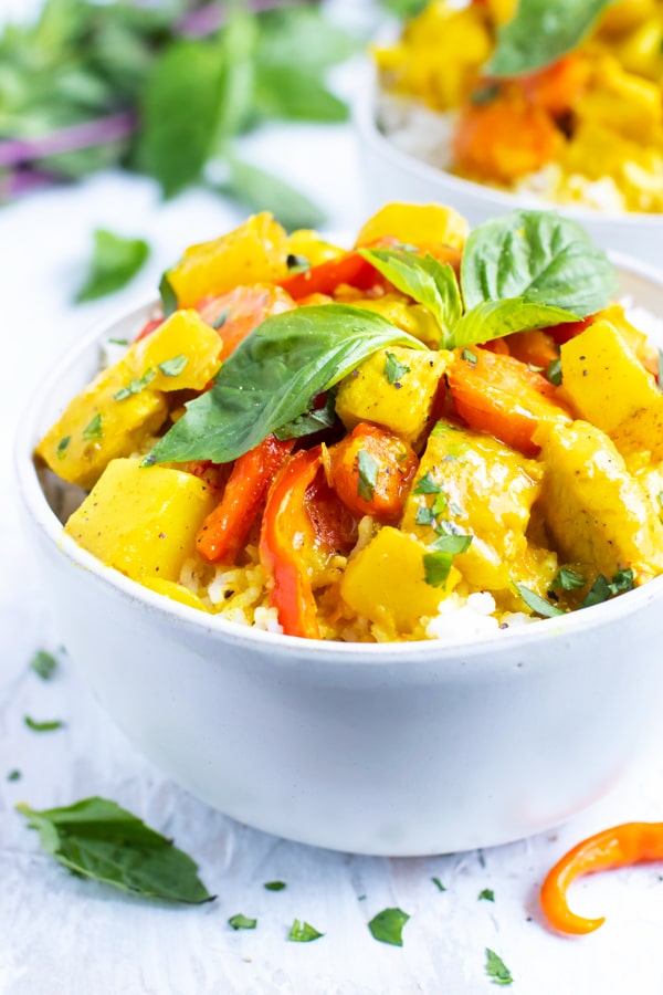 A white bowl full of a yellow curry recipe.