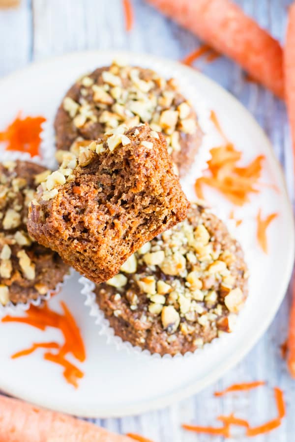 A paleo carrot cake muffin bitten into for a healthy treat.
