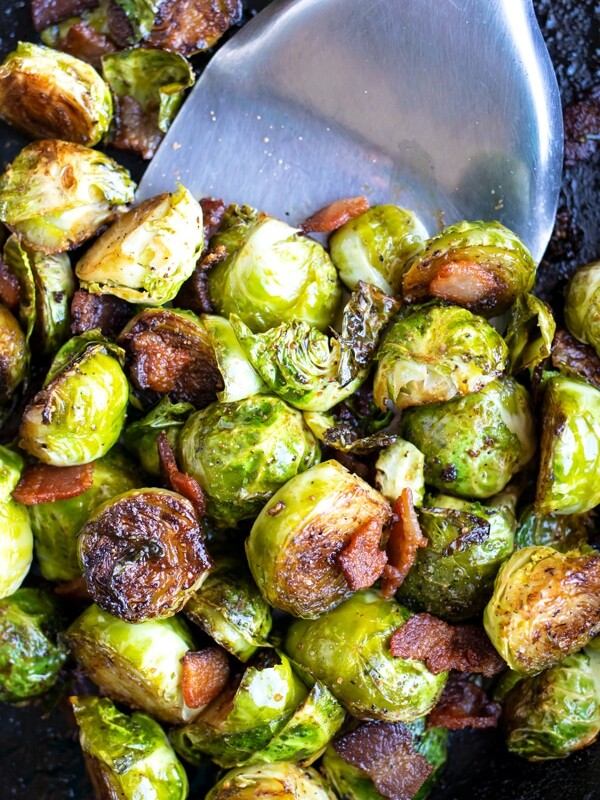 A cast iron skillet full of crispy and caramelized Brussels sprouts