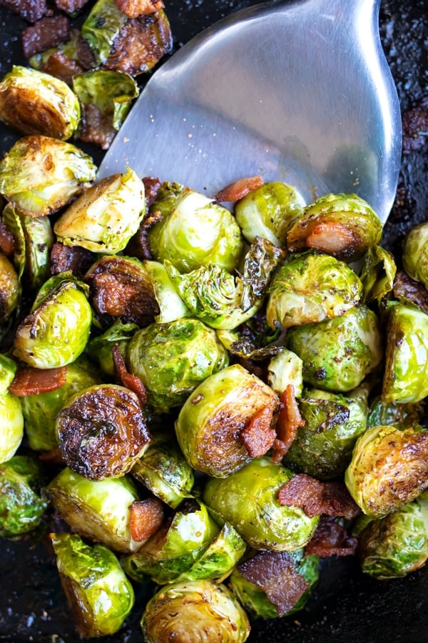 A cast iron skillet full of crispy and caramelized Brussels sprouts