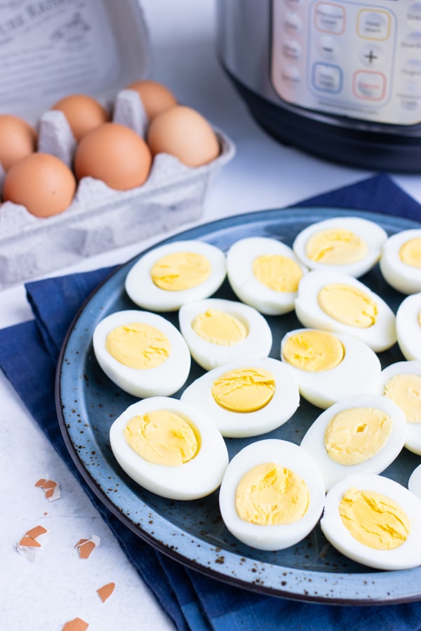 A serving platter full of hard-boiled eggs with an Instant Pot in the background.