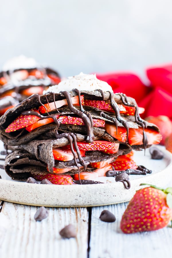 Paleo Chocolate Crepes with sliced strawberries on a plate for breakfast.