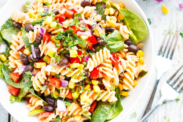 An overhead picture of Mexican pasta salad in a white bowl on a table.
