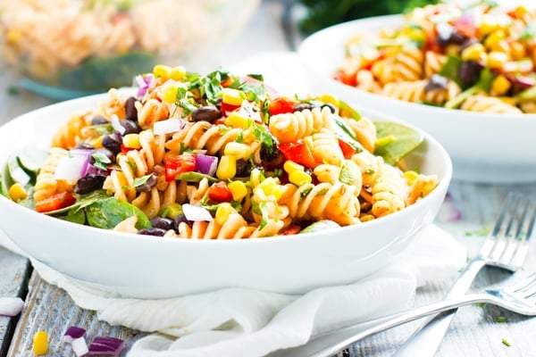 Gluten-free ranch pasta salad recipe in a white bowl with two forks.