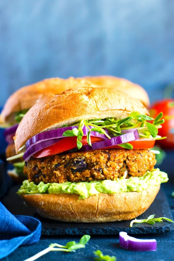 A Sweet Potato Black Bean Burger with quinoa on a slab with a blue napkin.